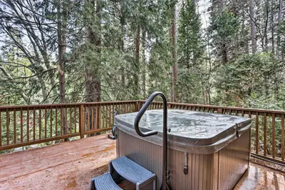 a hot tub on a deck with two chairs at Woodsy Twin Peaks Getaway with Hot Tub and Views! in Twin Peaks