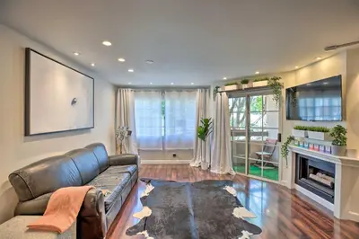 a living room with a leather couch and a fireplace at 2 Mi to Griffith Park! Burbank Extended-Stay Condo in Burbank