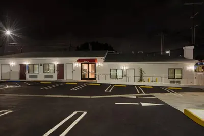 a building in a parking lot at night at Red Roof Inn Carson - Wilmington, CA in Wilmington