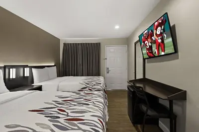 a hotel room with two beds and a flat screen tv at Red Roof Inn Carson - Wilmington, CA in Wilmington