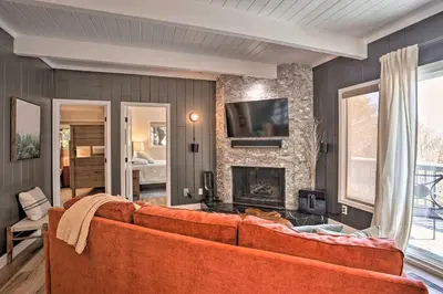 an orange couch in a living room with a fireplace at Stunning Lake Arrowhead Cabin with Lake Views! in Lake Arrowhead