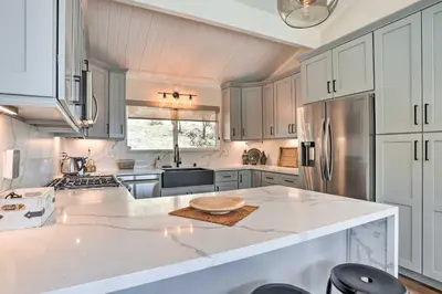 a kitchen with white cabinets and a large white counter top at Stunning Lake Arrowhead Cabin with Lake Views! in Lake Arrowhead