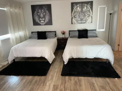 two beds in a bedroom with two tigers on the wall at Luxury Beachfront Condo - Endless Views - Surf 1 in Sunset Beach