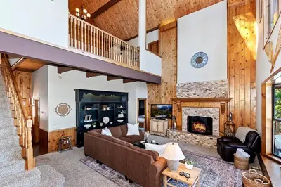 a living room with a couch and a fireplace at Stunning LAKE VIEW Game Room Spa Walk To Village in Lake Arrowhead