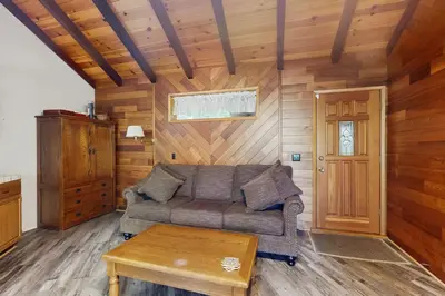 a living room with a couch and a table at Retro Cabin in Lake Arrowhead