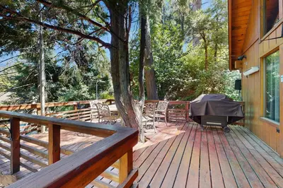 a wooden deck with a table and chairs on a house at Retro Cabin in Lake Arrowhead
