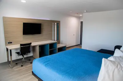 a bedroom with a bed and a desk with a television at Pico Rivera Inn and Suites in Pico Rivera