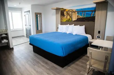 a bedroom with a blue bed in a room at Pico Rivera Inn and Suites in Pico Rivera