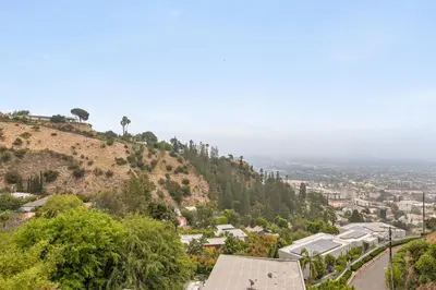 a view of a hill with trees and a city at The Hollywood Hills Crest Villa in Los Angeles