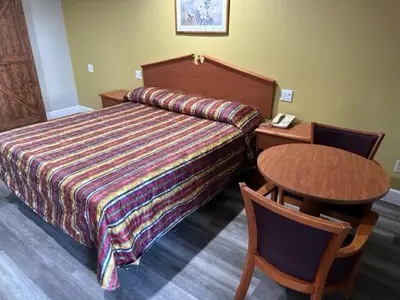 a hotel room with a bed and a table and a telephone at Chino Motel in Chino