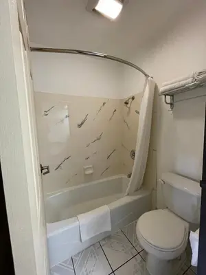 a bathroom with a tub and a toilet and a sink at Chino Motel in Chino