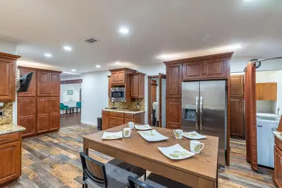 a large kitchen with a wooden table and appliances at Spacious Home with Garden & Pool in Northridge