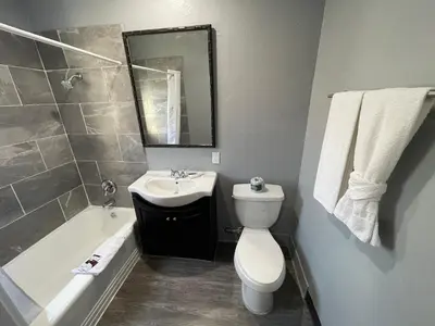 a bathroom with a toilet and a sink and a bath tub at Cornett Motel in Los Angeles
