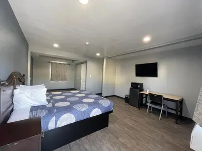 a hotel room with a bed and a desk at Cornett Motel in Los Angeles