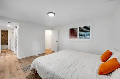 a white bedroom with a bed and a window at Red Cottage Charmer in Lake Arrowhead