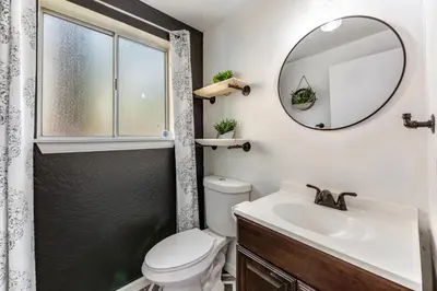 a bathroom with a toilet and a sink and a mirror at Blue Bird Beauty in Running Springs