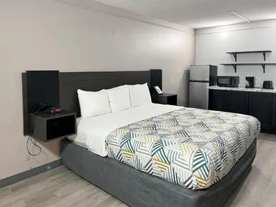 a bedroom with a large bed and a kitchen at Motel 6 Buena Park, CA Anaheim Near Maingate Knotts in Buena Park