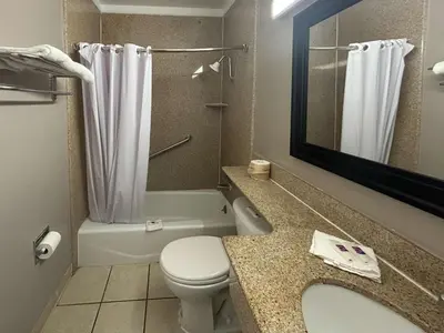 a bathroom with a toilet and a sink and a mirror at Motel 6 Buena Park, CA Anaheim Near Maingate Knotts in Buena Park