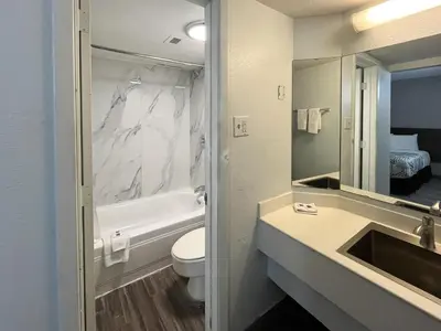 a bathroom with a sink and a toilet and a mirror at Motel 6 Buena Park, CA Anaheim Near Maingate Knotts in Buena Park