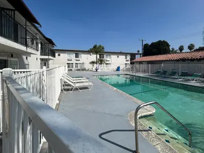 a swimming pool in front of a building at Motel 6 Buena Park, CA Anaheim Near Maingate Knotts in Buena Park