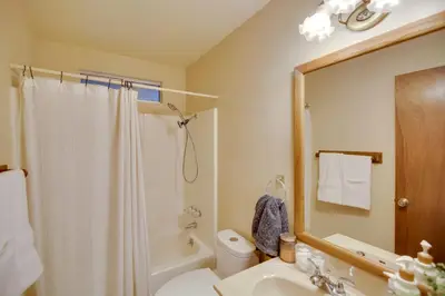 a bathroom with a sink and a toilet and a mirror at Peaceful and Idyllic Forest Cabin with Pool Table in Pine Mountain Club