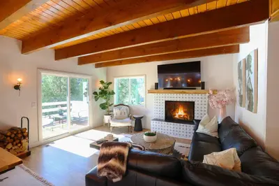 a living room with a couch and a fireplace at Picturesque Cabin 2 Balconies, Walk to Lake! in Crestline