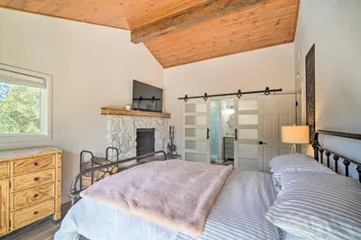 a bedroom with a bed and a fireplace at Picturesque Cabin 2 Balconies, Walk to Lake! in Crestline