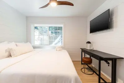a white bedroom with a bed and a desk at The Kingsley Hotel in Lake Arrowhead