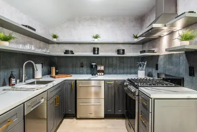 a kitchen with stainless steel appliances and gray walls at The Kingsley Hotel in Lake Arrowhead