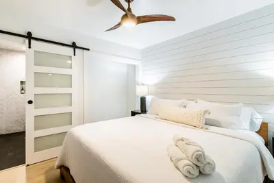 a bedroom with a white bed with a ceiling fan at The Kingsley Hotel in Lake Arrowhead