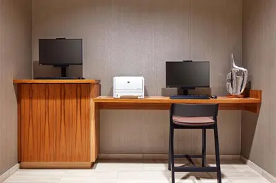 a desk with two computer monitors and a chair at SpringHill Suites by Marriott Los Angeles Downey in Downey