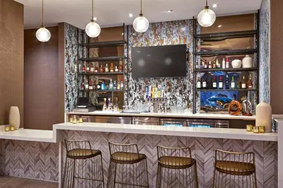 a bar in a hotel room with a tv at SpringHill Suites by Marriott Los Angeles Downey in Downey