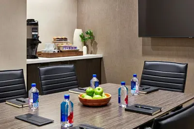 a table with a bowl of apples and bottles of water at SpringHill Suites by Marriott Los Angeles Downey in Downey