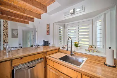 a kitchen with wooden counters and a sink and windows at Crestline Cabin with Deck 1 Mi to Lake Gregory in Crestline