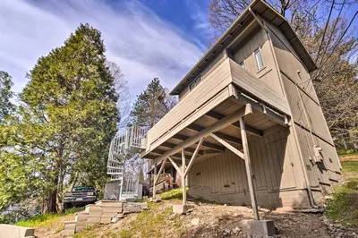 a house with a gambrel roof with a garage at Crestline Cabin with Deck 1 Mi to Lake Gregory in Crestline
