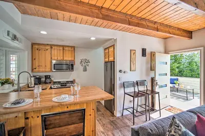 a kitchen and living room with a table and chairs at Crestline Cabin with Deck 1 Mi to Lake Gregory in Crestline