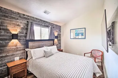 a bedroom with a bed and a brick wall at Crestline Cabin with Deck 1 Mi to Lake Gregory in Crestline