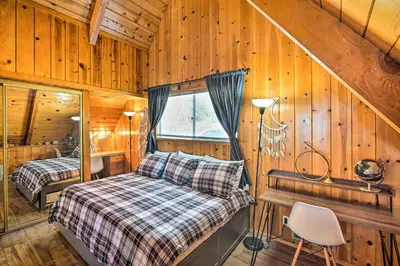 a bedroom with a bed and a window in a cabin at Running Springs Cabin with Large Deck and View! in Running Springs