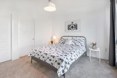 a white bedroom with a bed and a table at LA Harbor Home with Private Rooftop near #DTLA in San Pedro