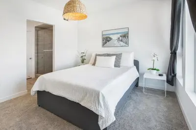 a white bedroom with a large bed with white sheets at LA Harbor Home with Private Rooftop near #DTLA in San Pedro