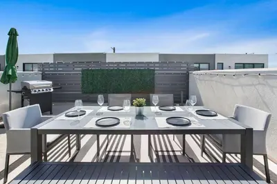 a white table and chairs on a patio at LA Harbor Home with Private Rooftop near #DTLA in San Pedro