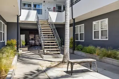 a stairway leading to a house with a bench at Spacious Coastal Apartment in a Colorful Community - NRP22-00590 in Long Beach