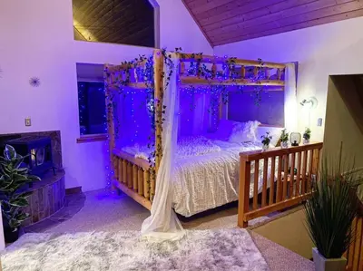 a bedroom with a canopy bed with purple lighting at Sweet getaway in private Giant Sequoia Grove! in Springville