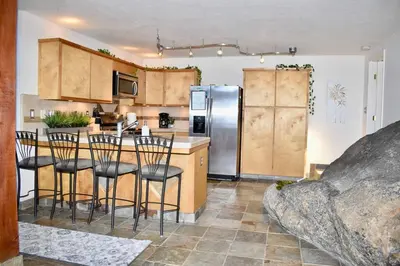 a kitchen with wooden cabinets and a refrigerator at Sweet getaway in private Giant Sequoia Grove! in Springville