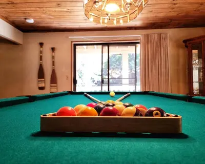 a bowl of fruit on top of a pool table at Treehouse Cottage in Crestline