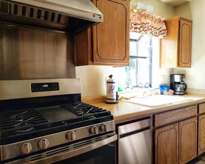 a kitchen with a stove and a sink at Treehouse Cottage in Crestline