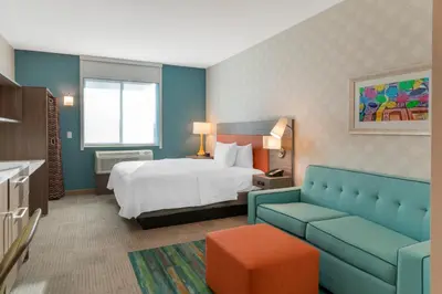 a hotel room with a bed and a couch at Home2 Suites By Hilton Redlands in Redlands