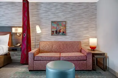 a living room with a couch and a bed at Home2 Suites By Hilton Garden Grove in Garden Grove