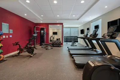 a gym with a row of treadmills and exercise bikes at Home2 Suites By Hilton Garden Grove in Garden Grove