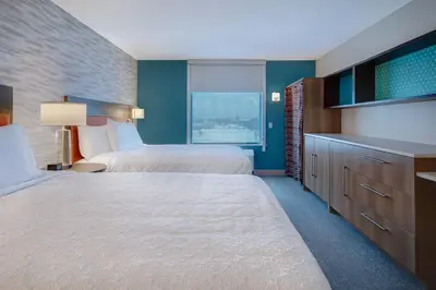 a hotel room with two beds and a television at Home2 Suites By Hilton Garden Grove in Garden Grove